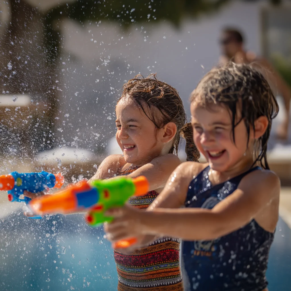 two children having fun with water play in their back yard
